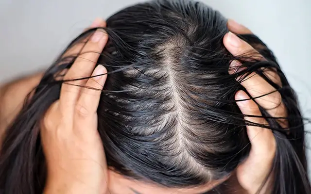 woman applying product to her hair